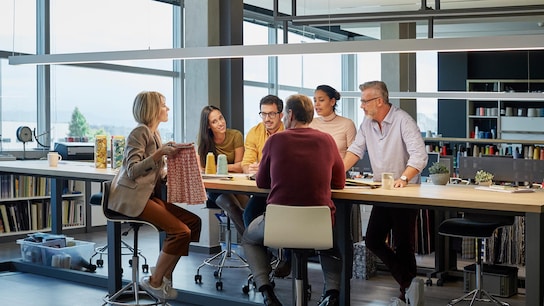 Business people discussing over fabric at conference table