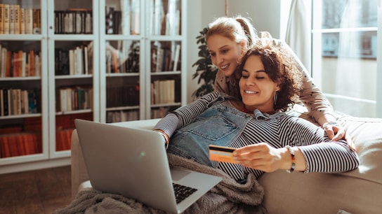 Cybersecurity - female couple using laptop on sofa
