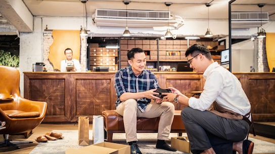 Making ‘Decent Work’ a habit in global supply chains - Salesman introducing new shoes to customer in a shoe store