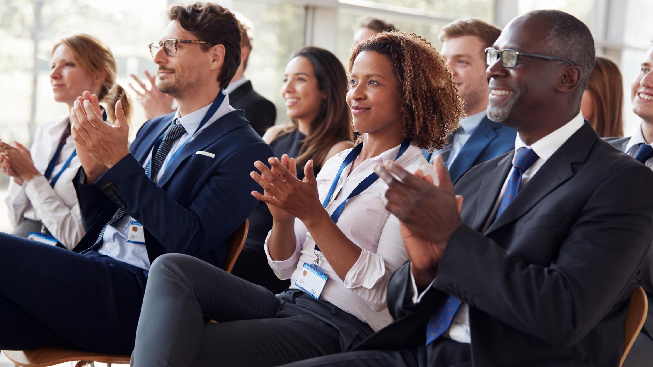 Applauding group in suits at a presentation