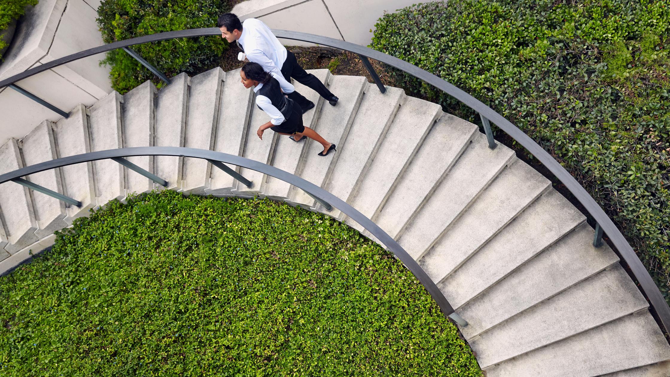 people walking up spiral outdoor stairs