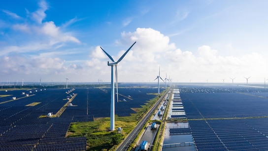 Solar power stations in plain areas, wind turbines in the distance
