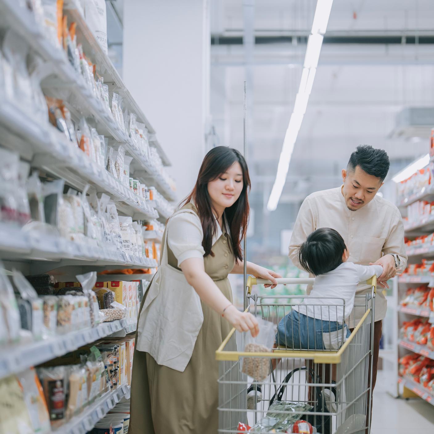 Family buying groceries in supermarket refrigerated section