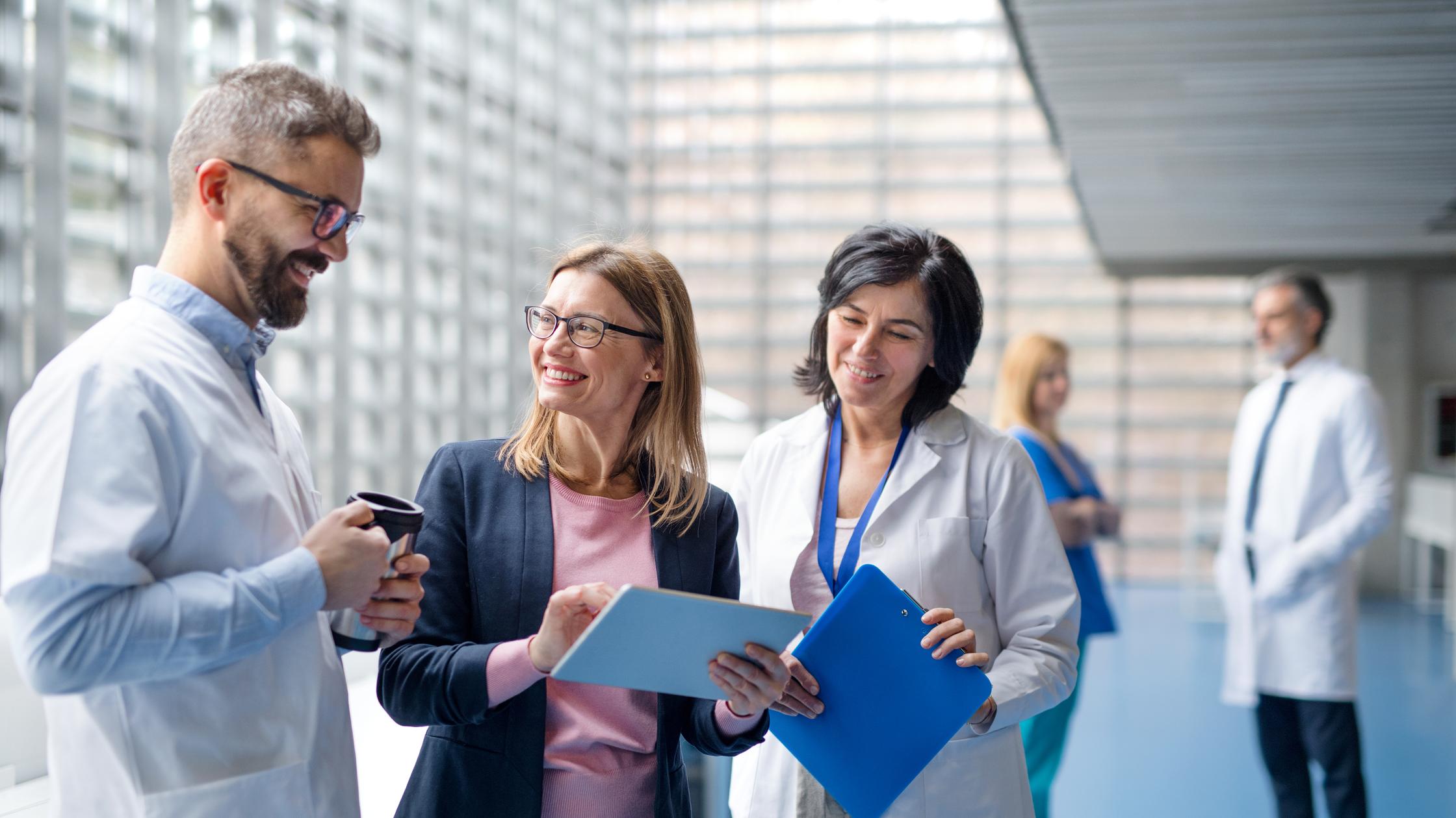 Group of doctors talking to pharmaceutical sales representative on conference