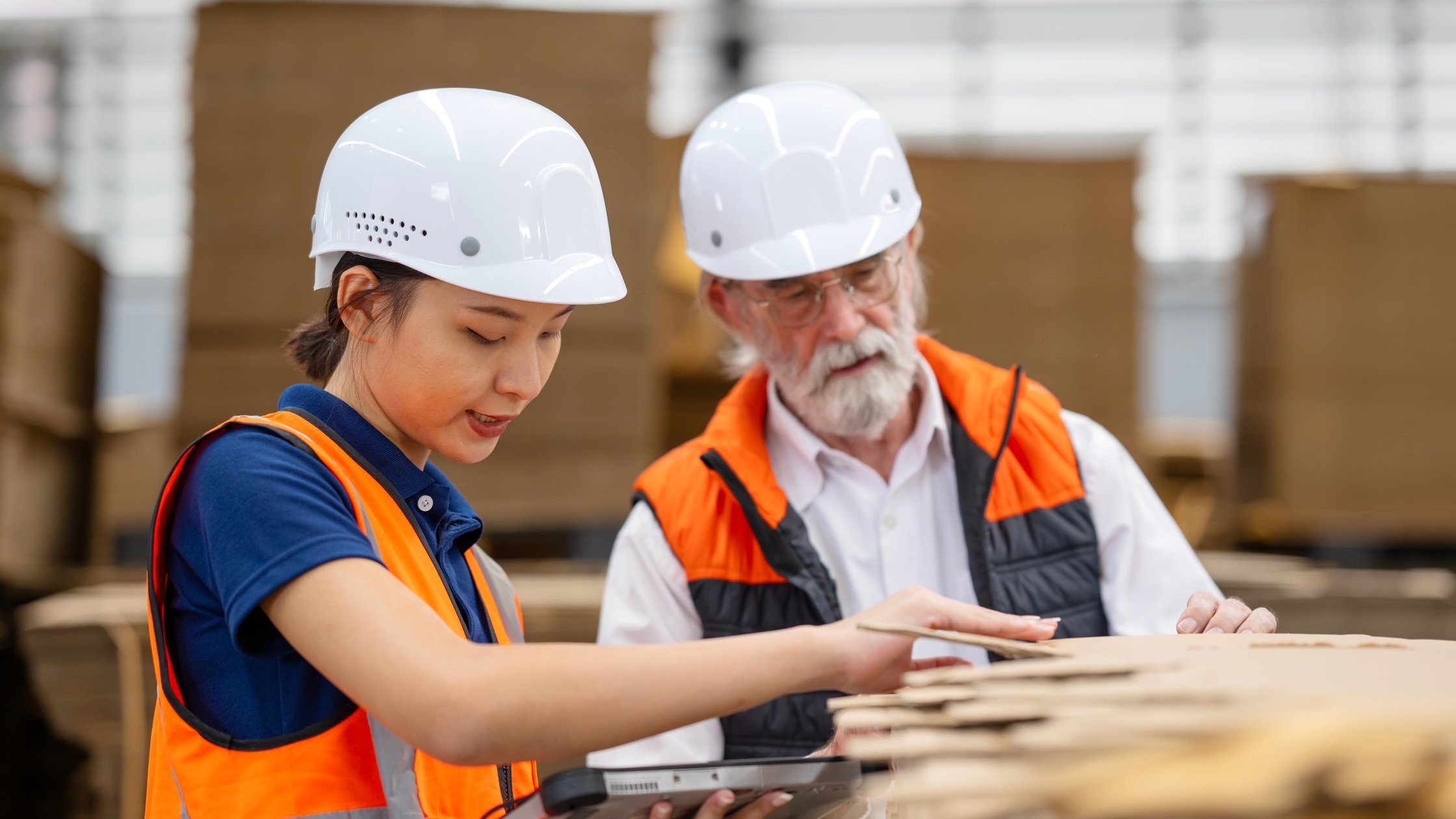 How standards are made - A female quality control engineer and senior male manager examine the quality of raw corrugated material