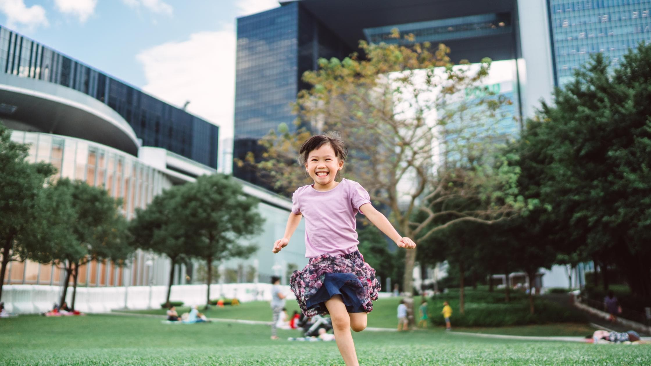 little girl running on lawn in park
