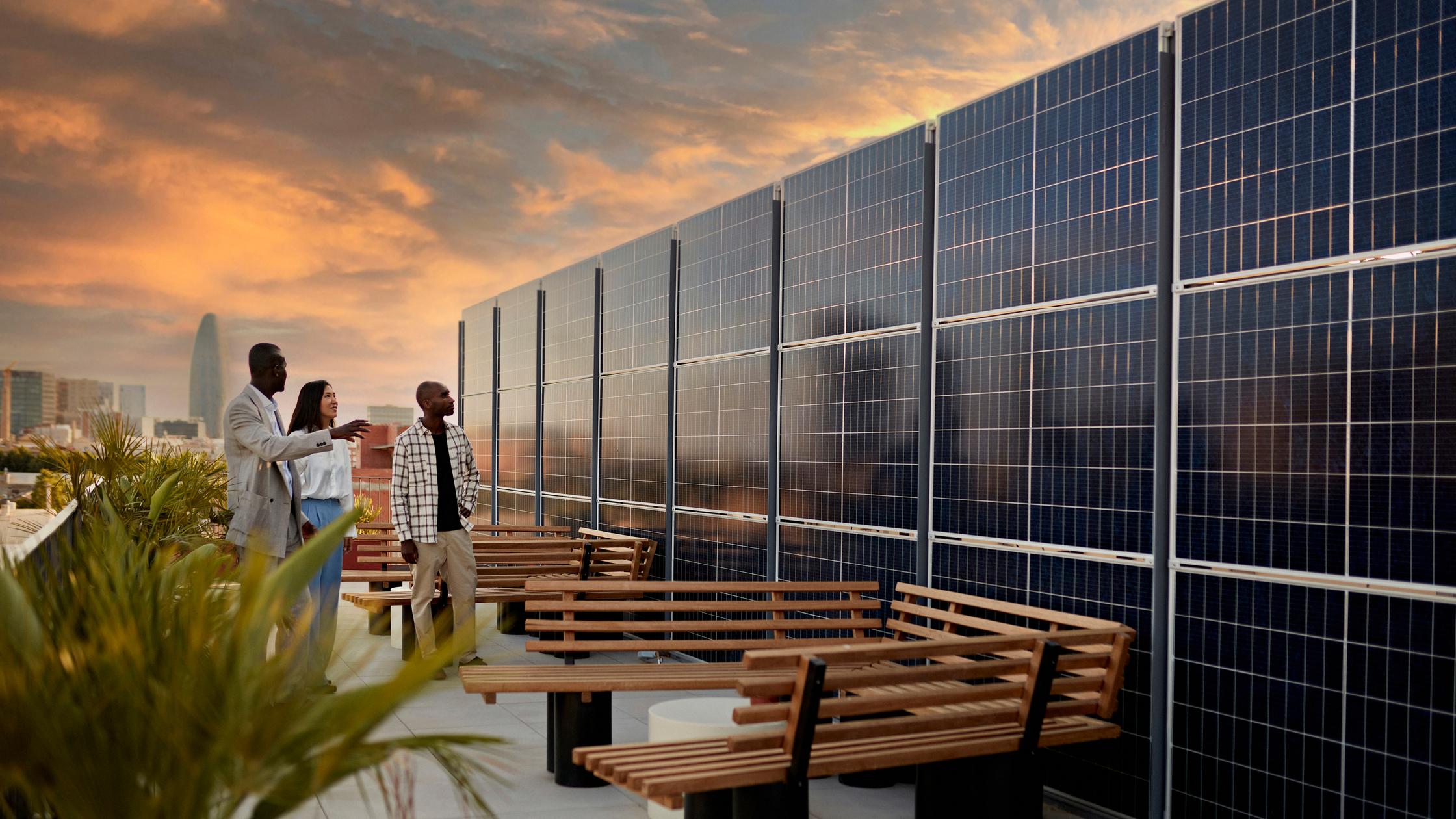 Real estate agent and couple standing on rooftop of environmentally aware office building