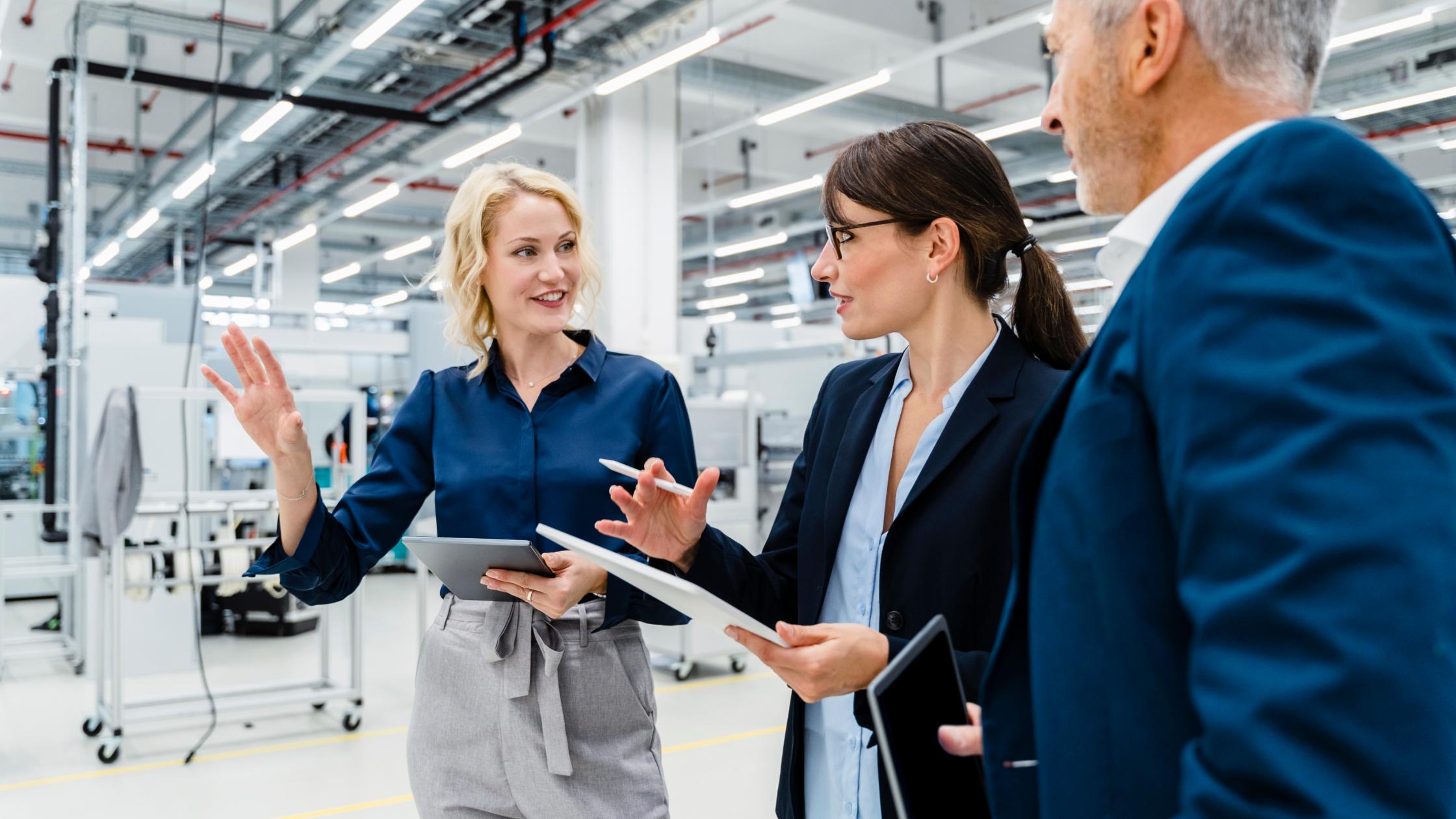 Business people having discussion at automated factory.