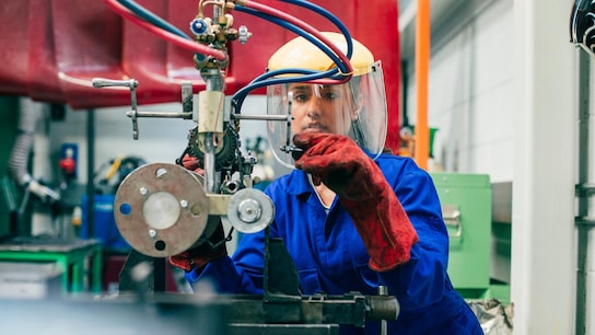 A young woman is using engineering equipment in a workshop