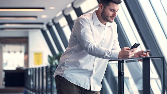 Male consumer paying on his phone with a credit card.
