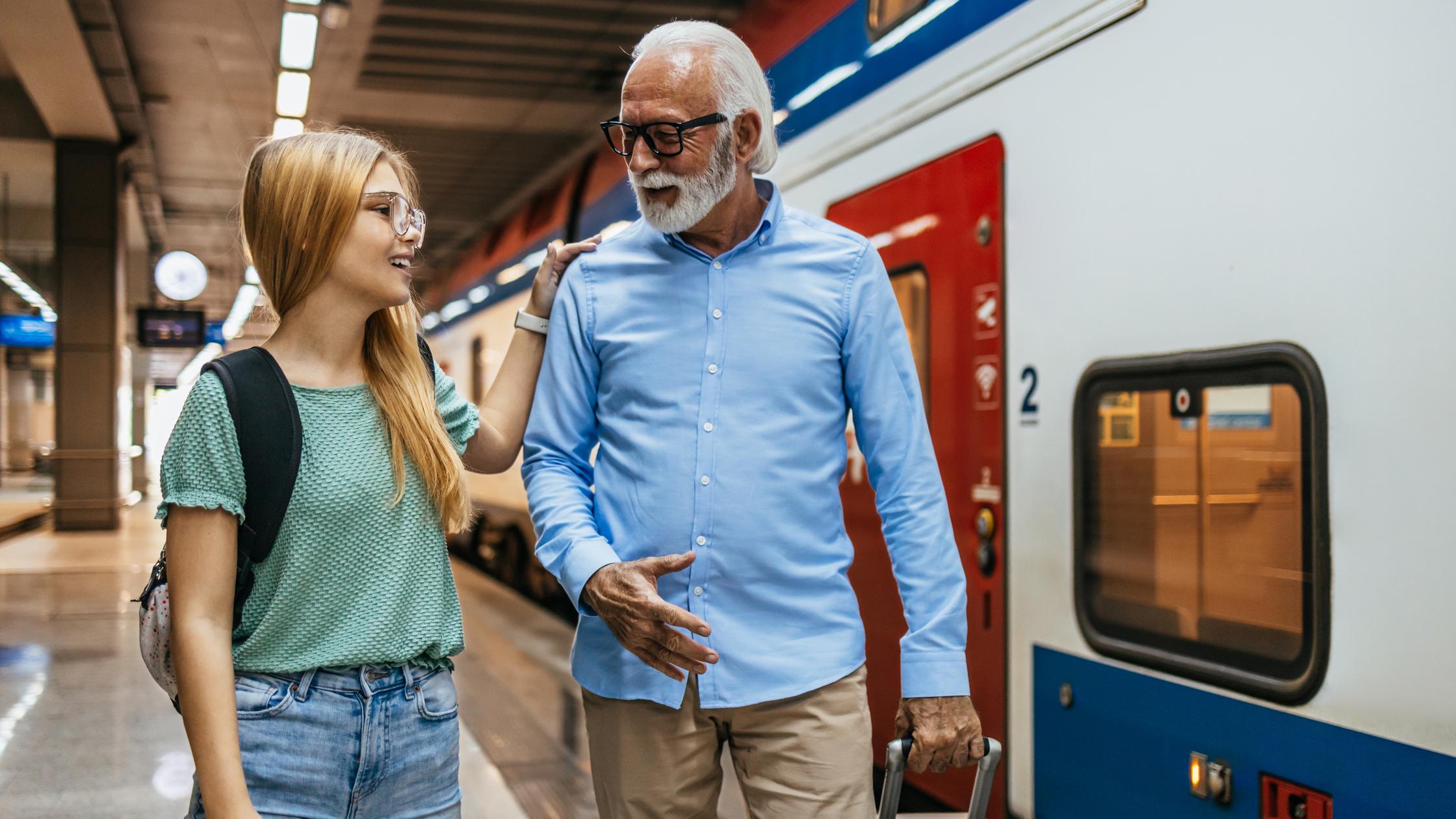 Senior businessman waiting for a fast train or metro together with his granddaughter 