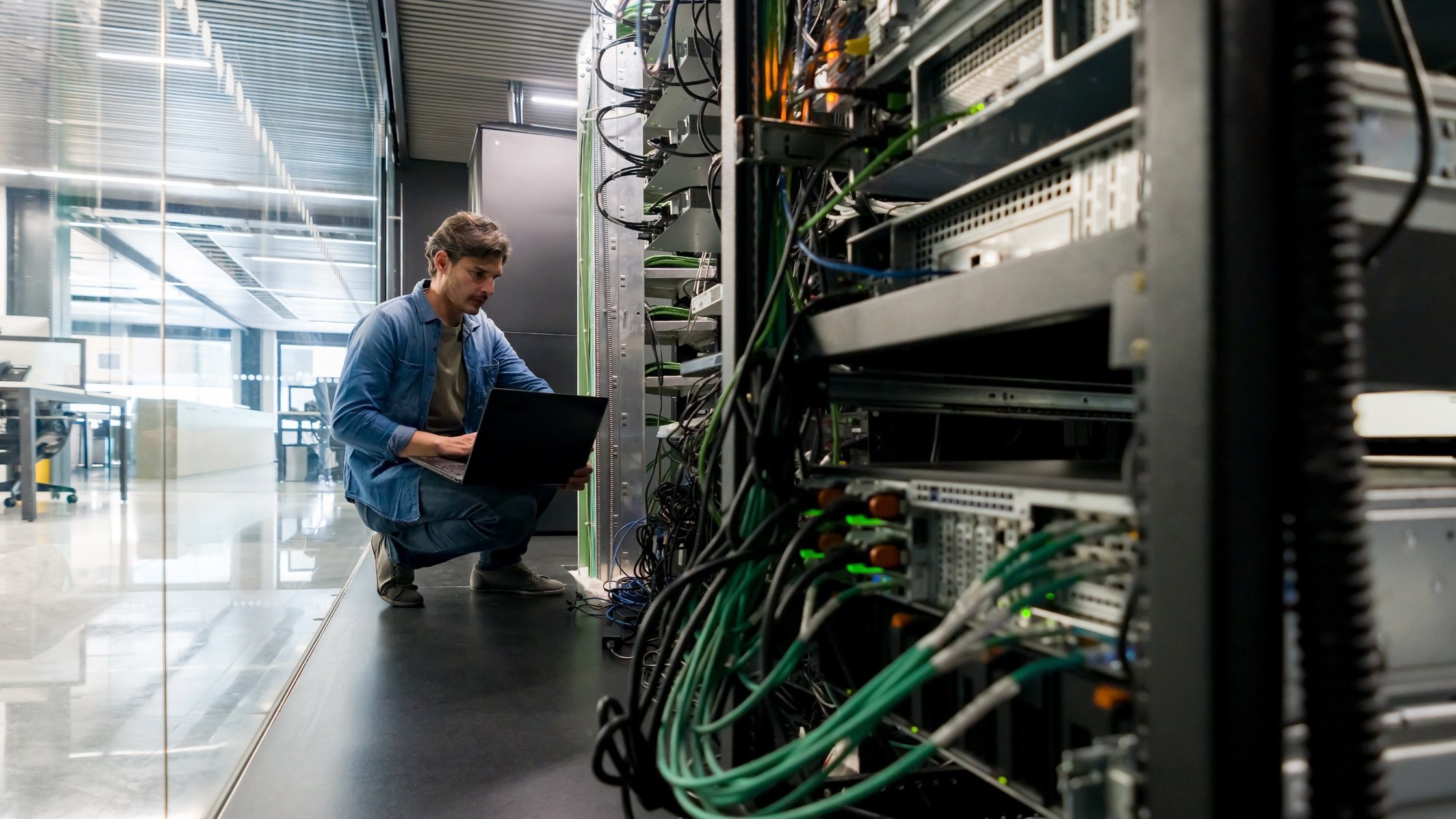 Computer technician fixing a network server the office - focus on foreground