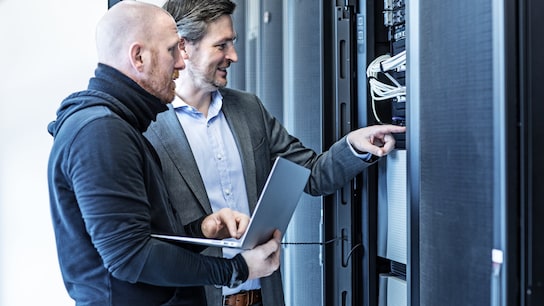 Technicians men and manager working together in server room setting