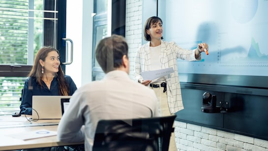 A diverse business development team plans a marketing strategy using customer insights from digital displays to launch a campaign.