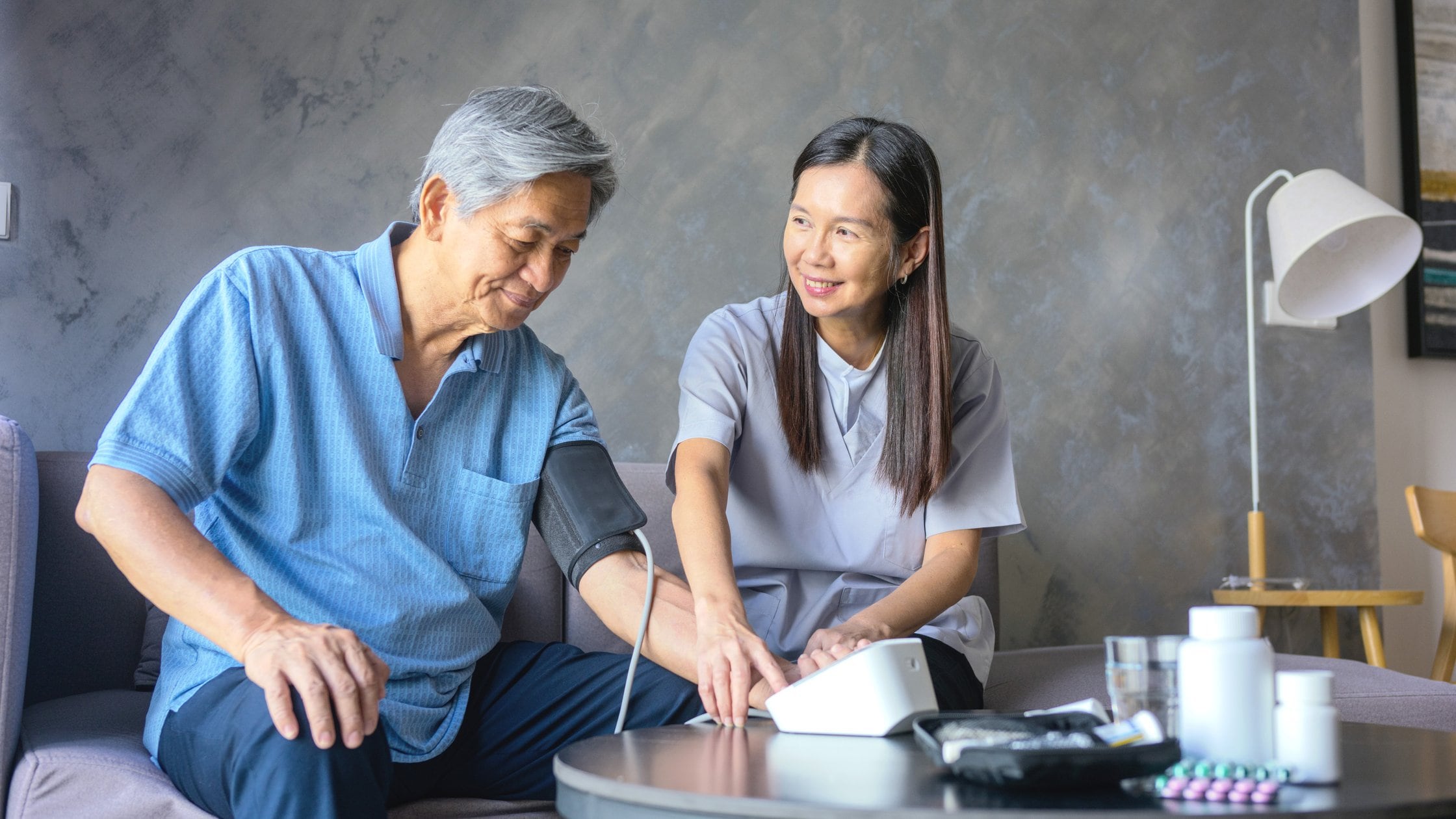 Two asians people talking sitting on a couch