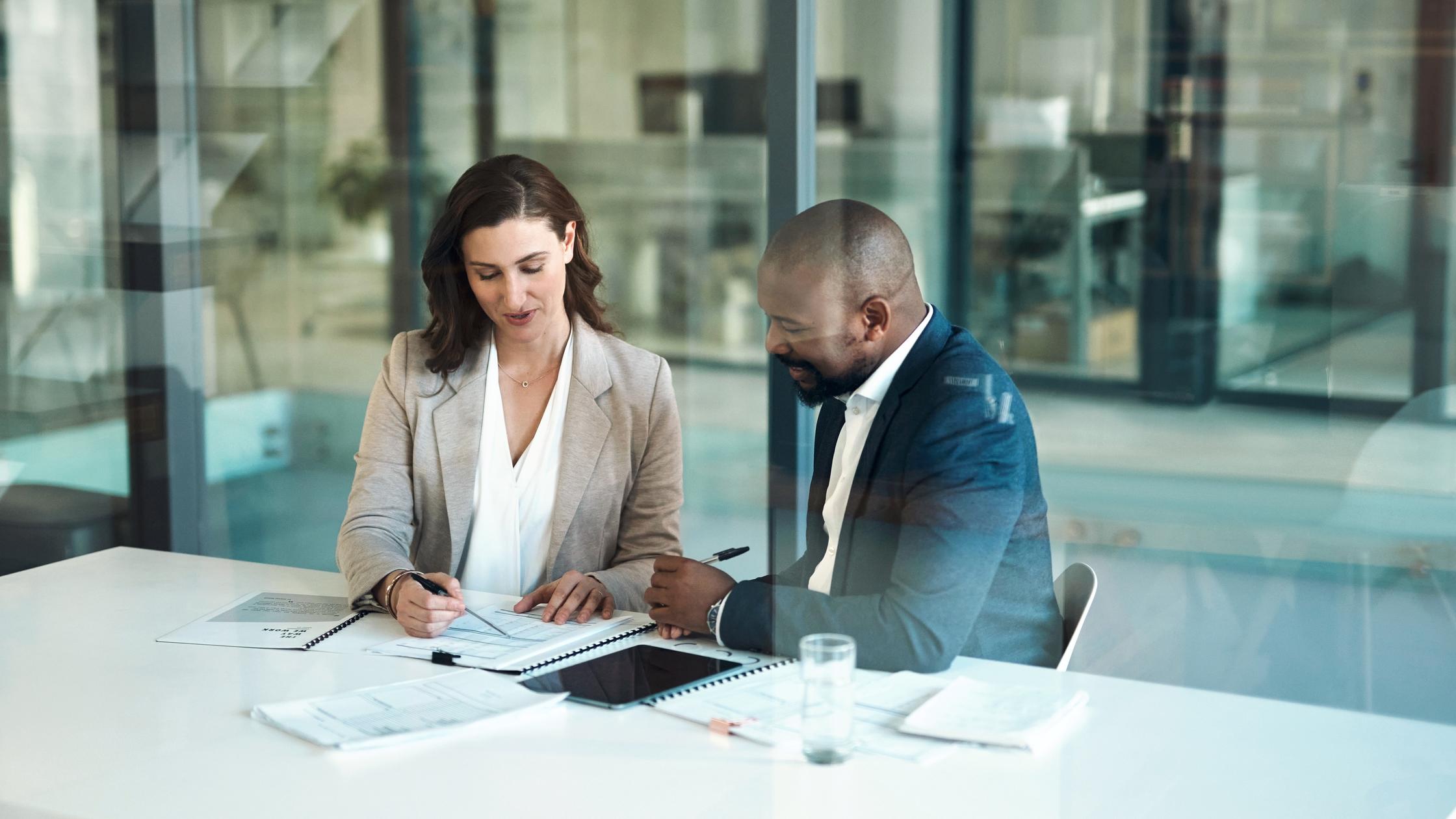 Two business people discussing about documents in an office