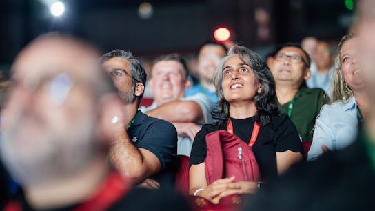 A woman assisting to an event seated in a crowd