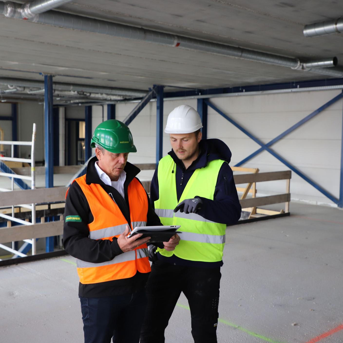 Two men in hard hats in warehouse